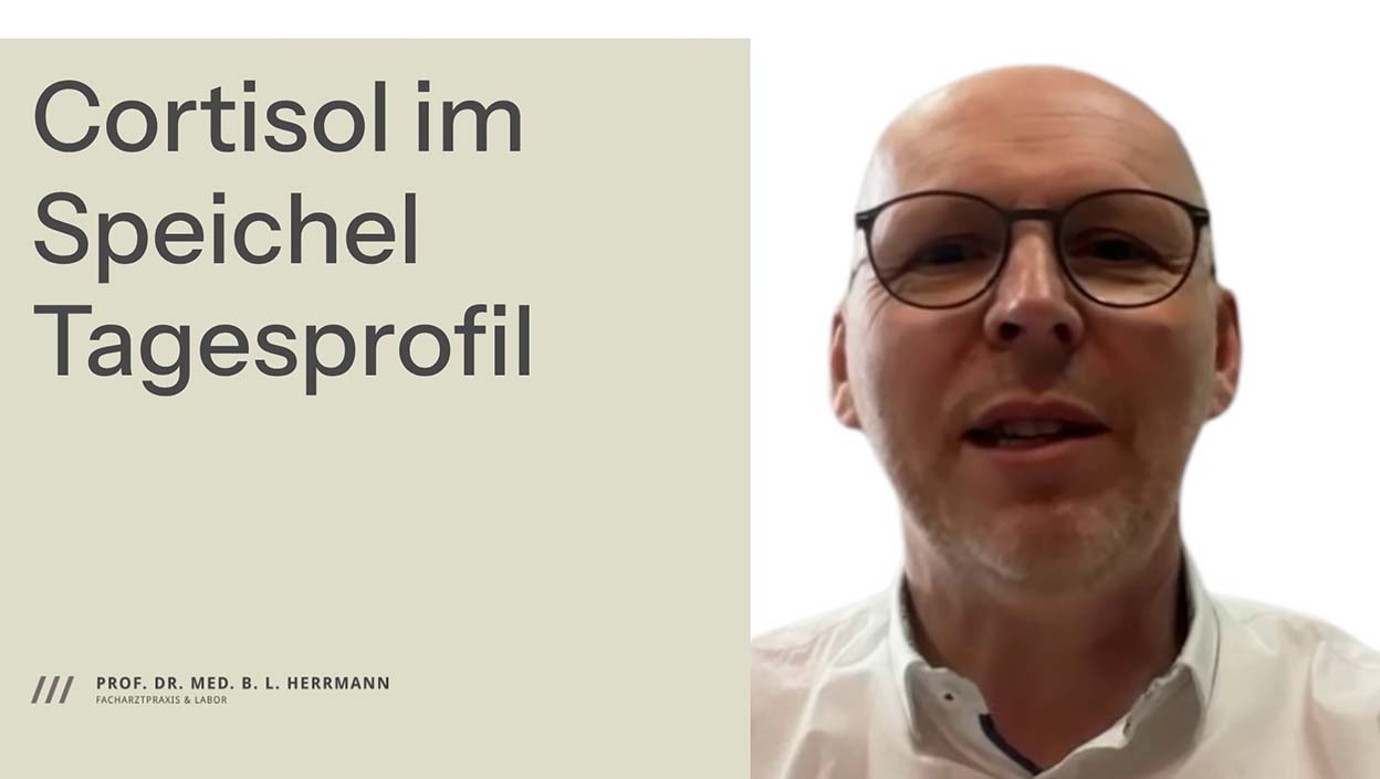 Prof. Dr. Herrmann und weißem Hemd, der in einer Info-Video-Präsentation über das Cortisol-Speichelprofil spricht