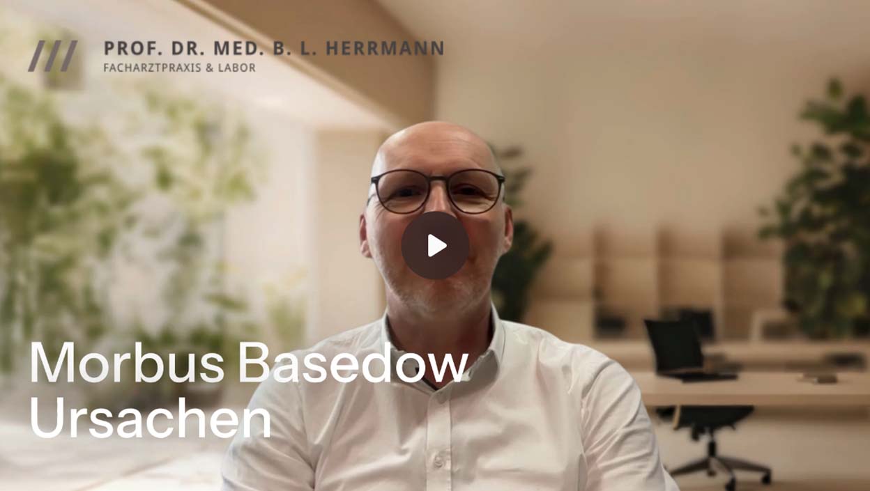 Prof. Dr. Herrmann in weißem Hemd mit Brille vor einem Video-Play-Button